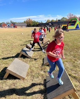 Students running an obstacle course at the Fun Run