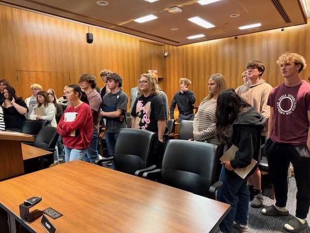 Students standing in a court room.