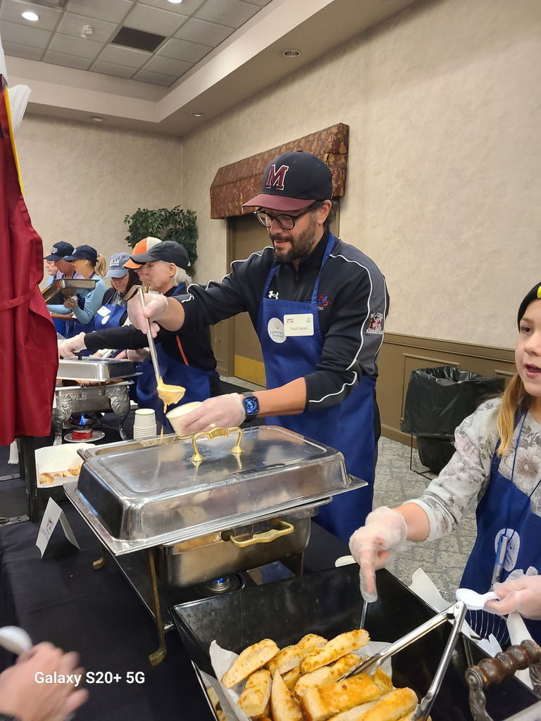 Dr Salah putting soup in a bowl for a Fight the Hunger fundraising event