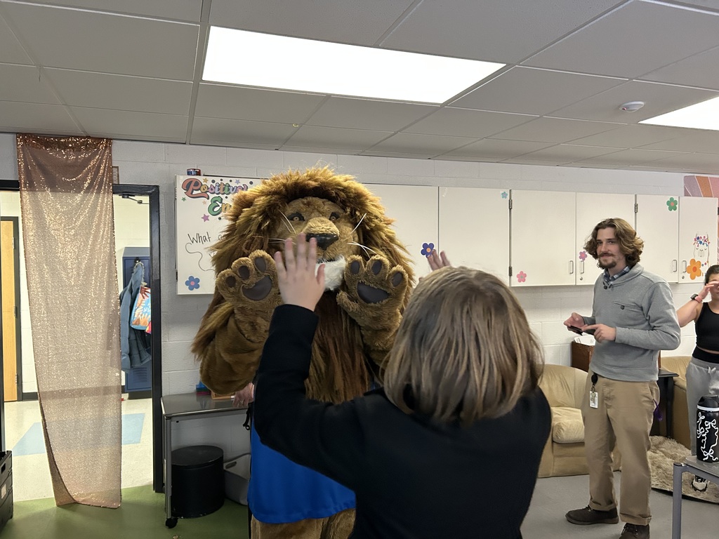 Roary the Lion high fiving a 5th grader