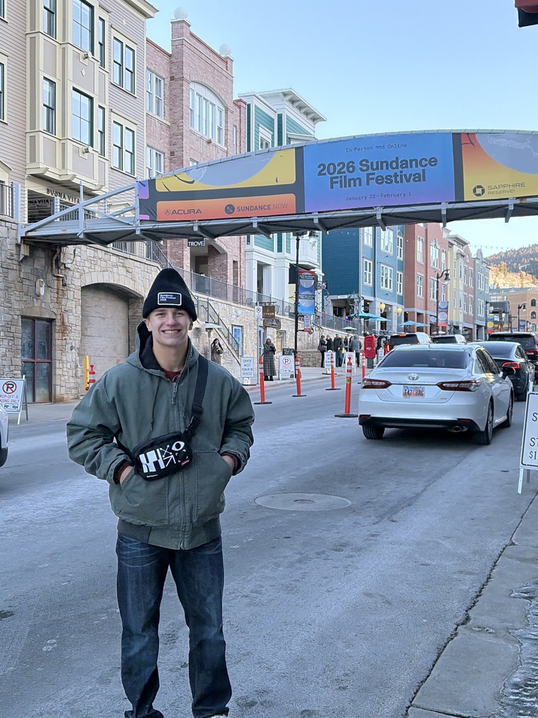 HVS student standing in front of 2026 Sundance film festival billboard in city street
