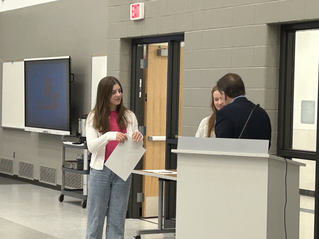 Tom Wiseman presenting certificate to two students