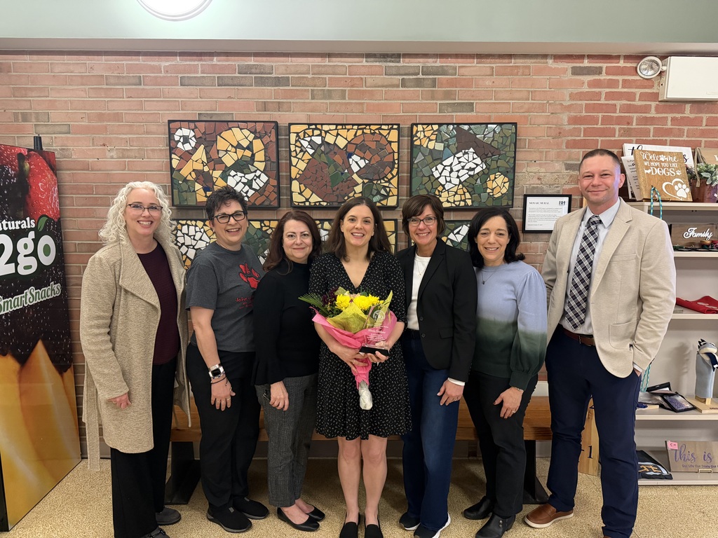 Photo of Nicole Grabow for Oakland County Social Worker of the Year holding flowers with other HVS educators