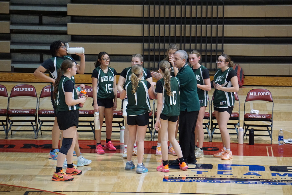 Picture of team with Coach Topper in a huddle