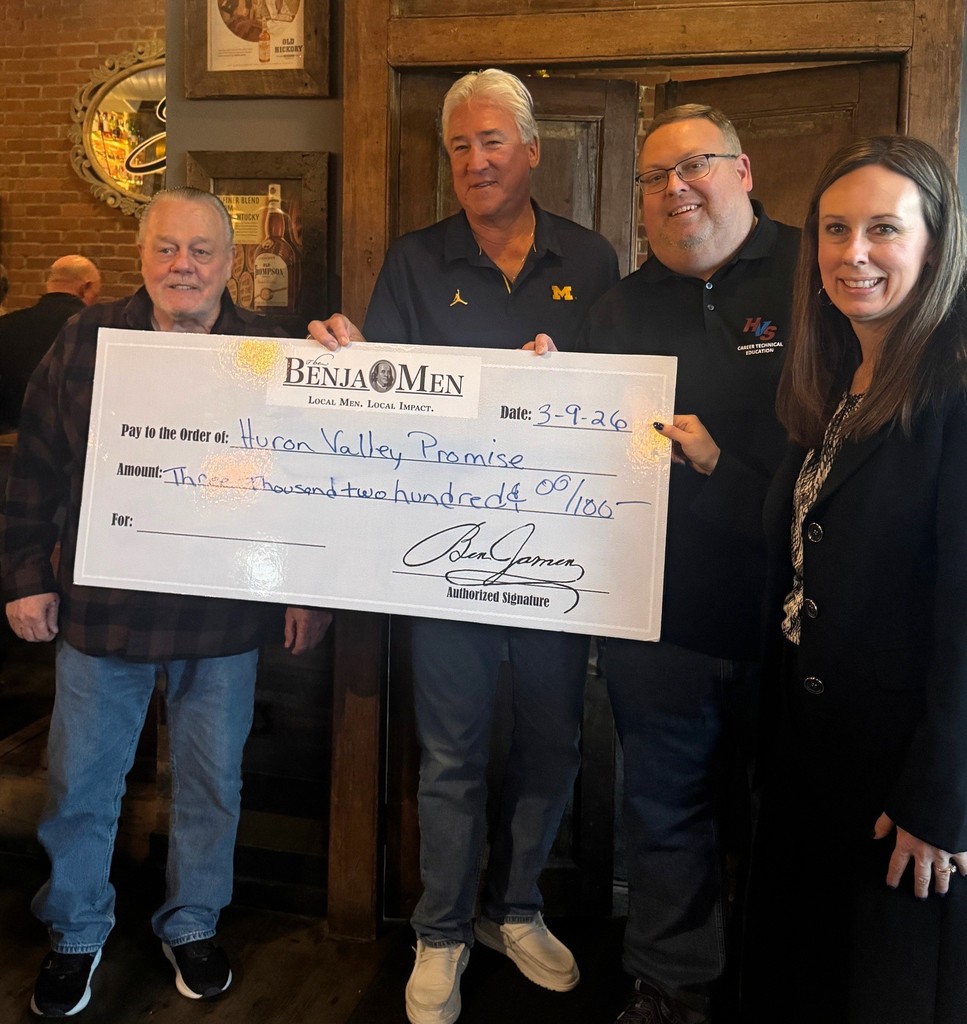 Several community members holding a check for $3,200  from the Benjamin Group for the Huron Valley Promise