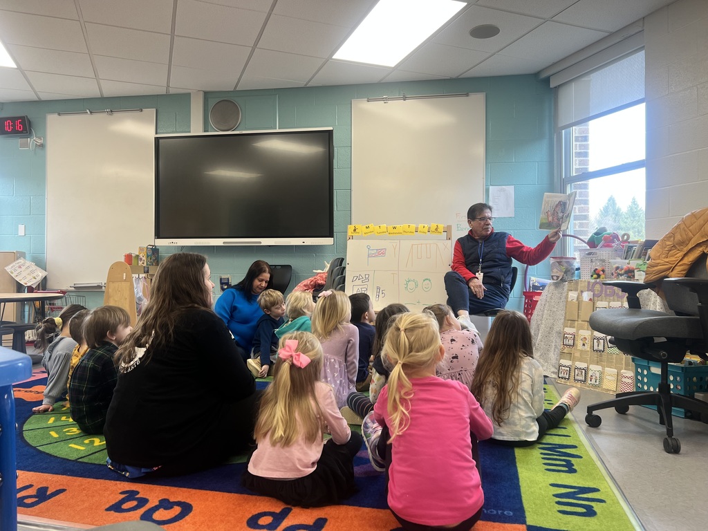 HVS Board member Tom Wiseman reading a book to kids who are sitting on the floor listening