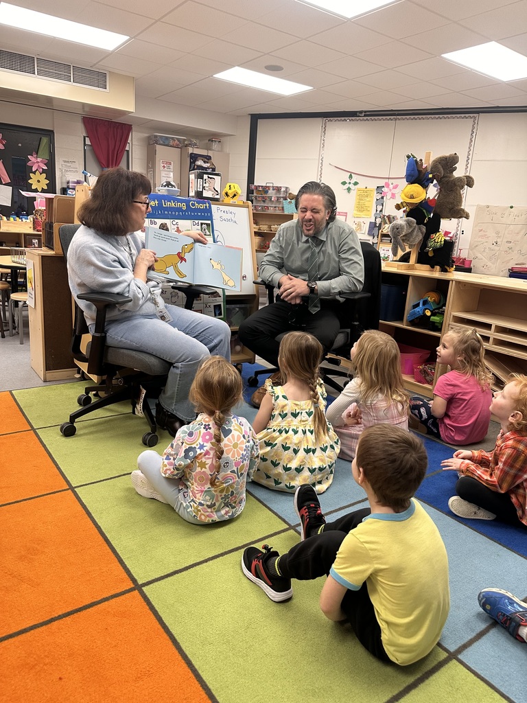 HVS superintendent Paul Salah & Board member Denise Pistana reading a book to kids who are sitting on the floor listening