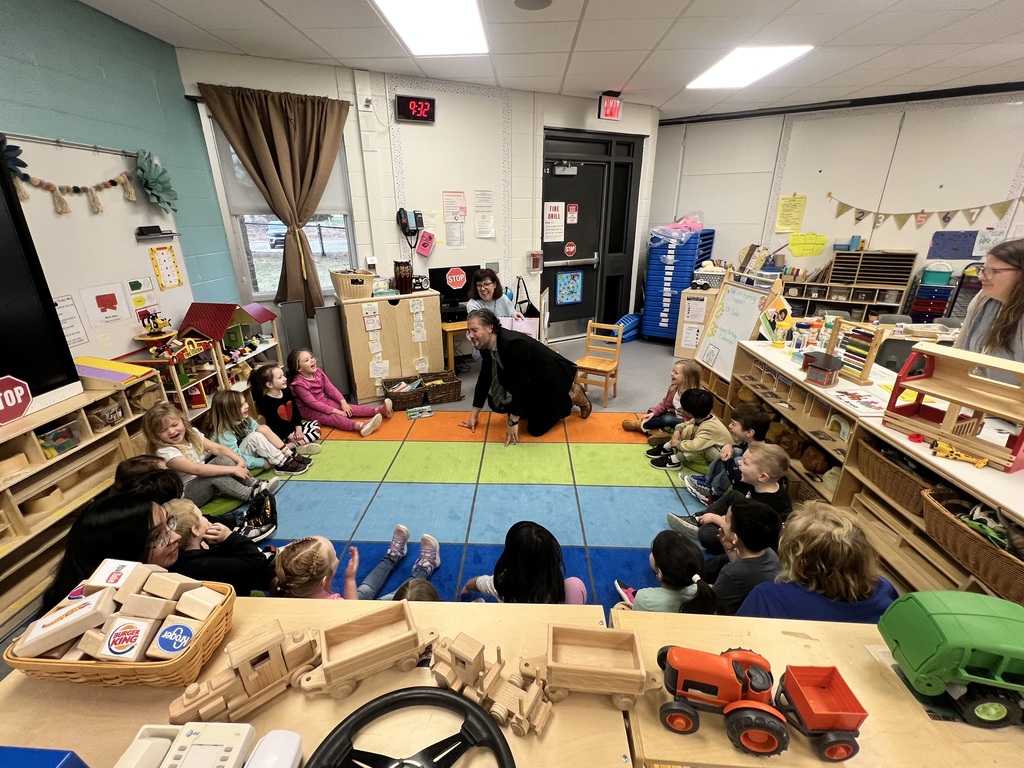 HVS superintendent Paul Salah & Board member Denise Pistana reading a book to kids who are sitting on the floor listening