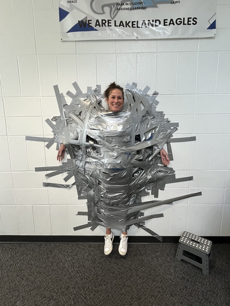 Long distance shot of Hollowell taped to wall smiling