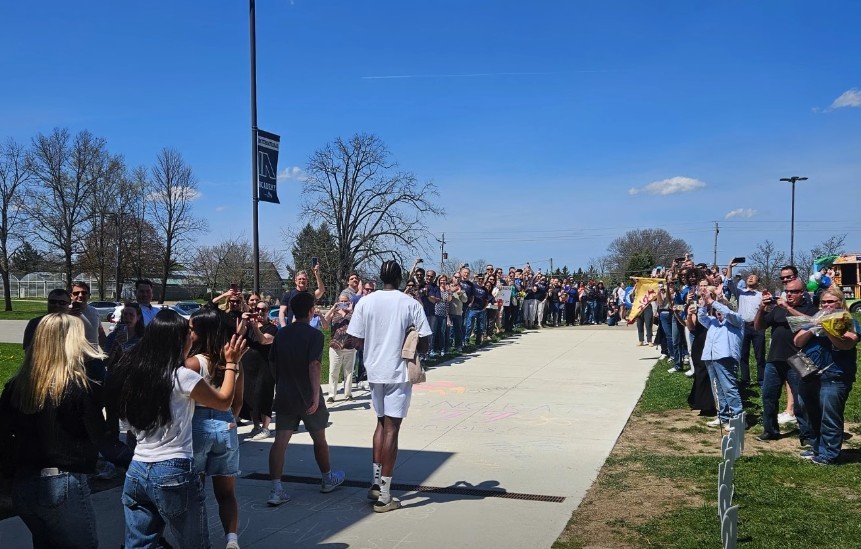 IAWest students walking out on the last day of classes with family around clapping 