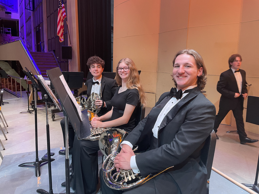 Three members of the HV Wind Ensemble on stage with their instruments
