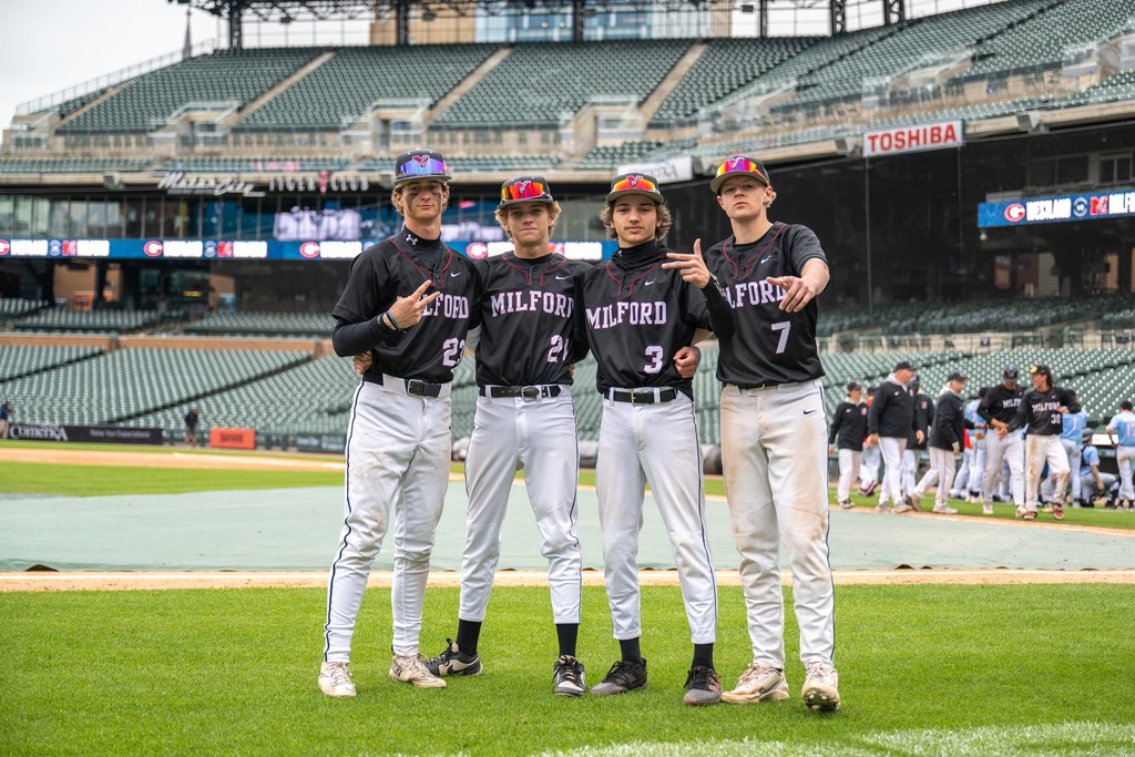 4 MHS baseball players posing for photo on the field at comerica park