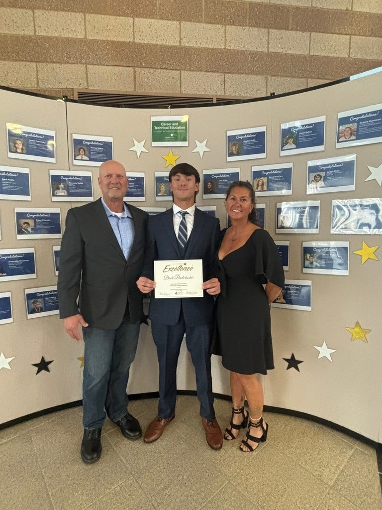 Photo of Brok Badertscher holding CTE excellence certificate flanked by his parents
