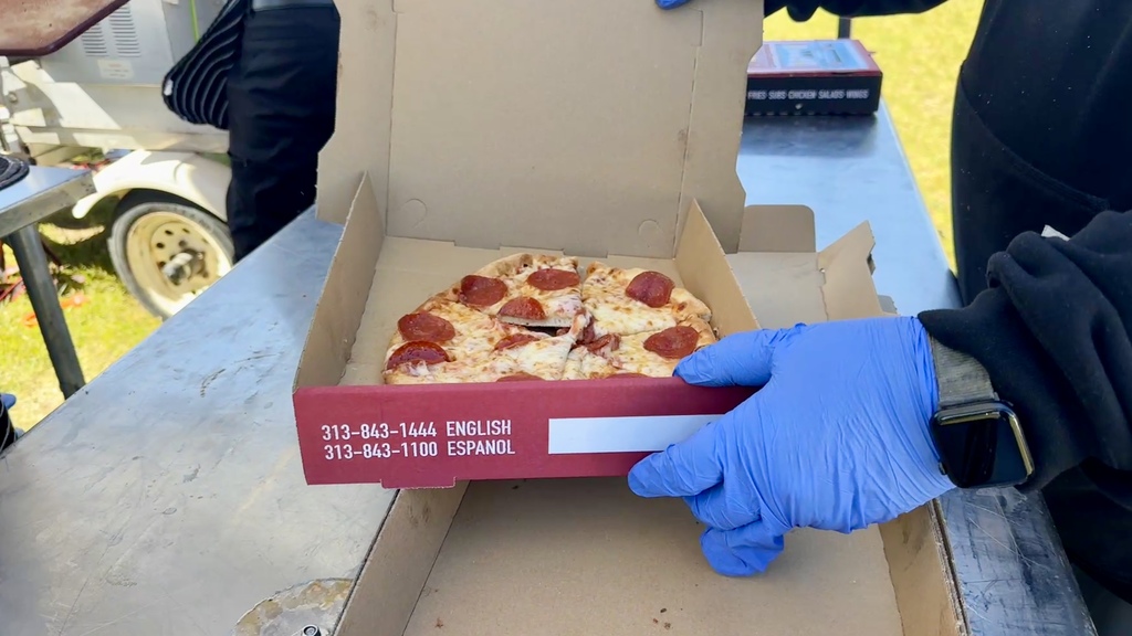 photo of pizza being placed into a to-go box