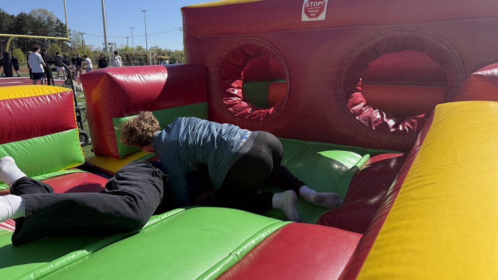 Photo of students playing a game in an inflatable on football field at MHS
