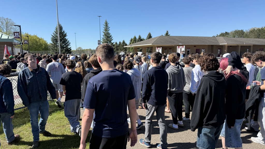 Photo of students leaving the football field on a sunny day
