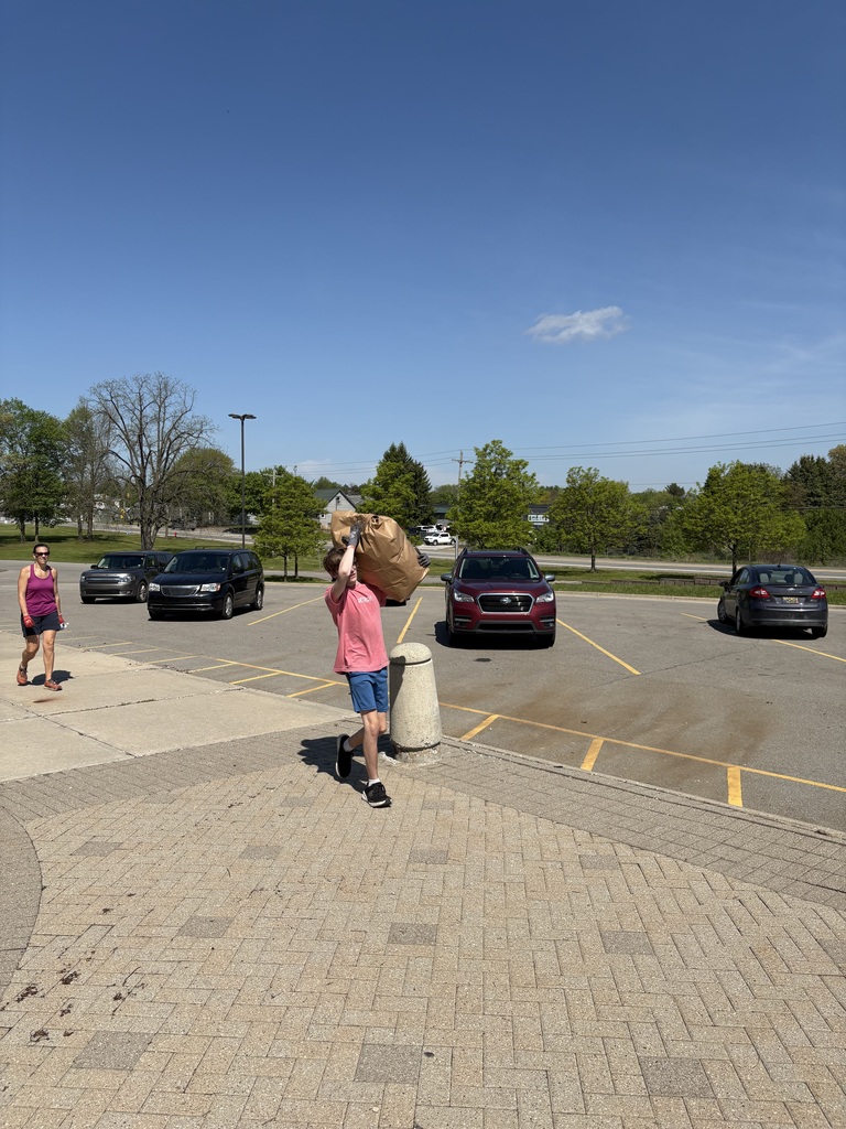 Person lifting yard waste bag over head