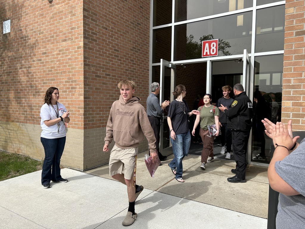 Milford seniors walking outside to parents for clapout