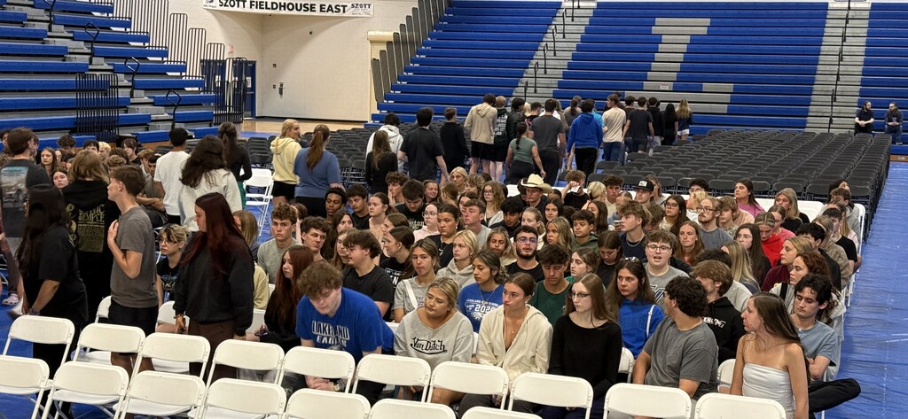 SHOT OF SEVERAL STUDENTS SITTING DURING A GRADUATION REHEARSAL