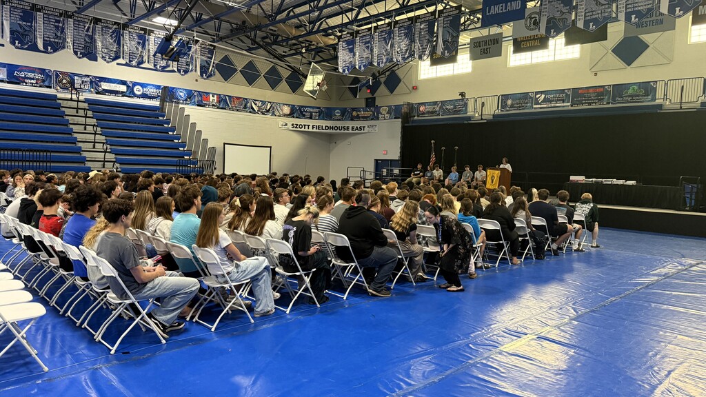 SHOT OF SEVERAL STUDENTS SITTING DURING A GRADUATION REHEARSAL