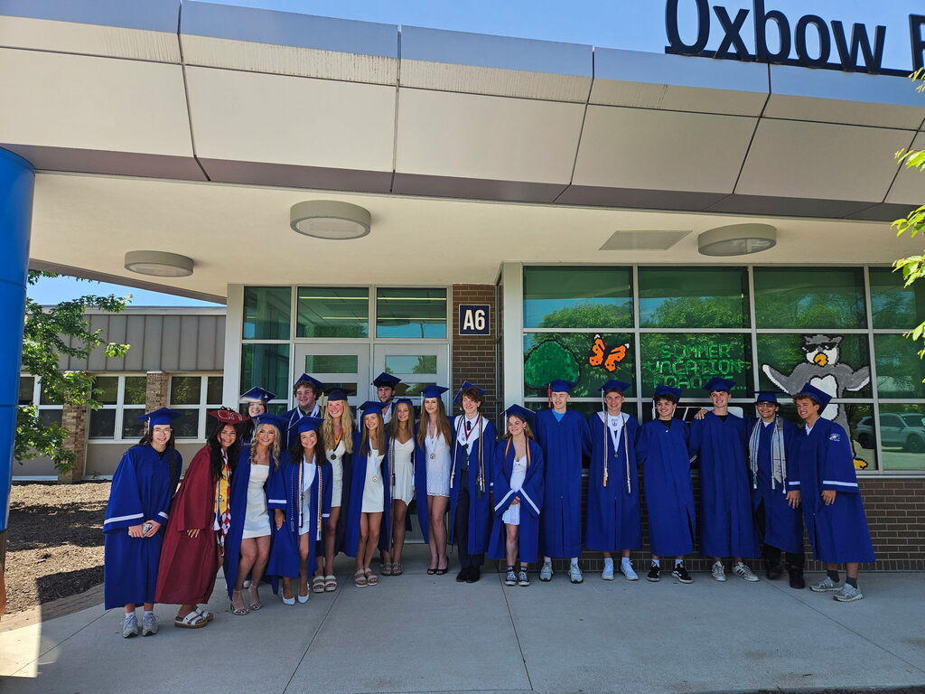 Several HVS seniors in cap & gown for graduation visiting elementary school posing for picture