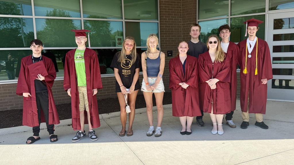 Several HVS seniors in cap & gown for graduation visiting elementary school pose for picture