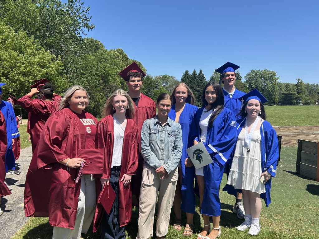 Several HVS seniors in cap & gown for graduation visiting elementary school on the playground