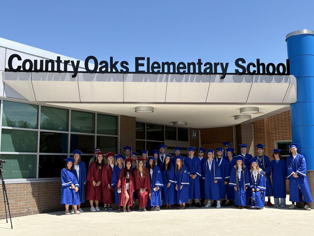 Several HVS seniors in cap & gown for graduation visiting elementary school pose for picture