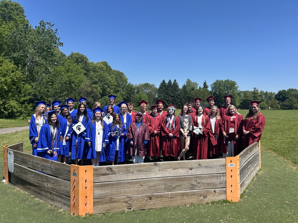 Several HVS seniors in cap & gown for graduation visiting elementary school on the playground