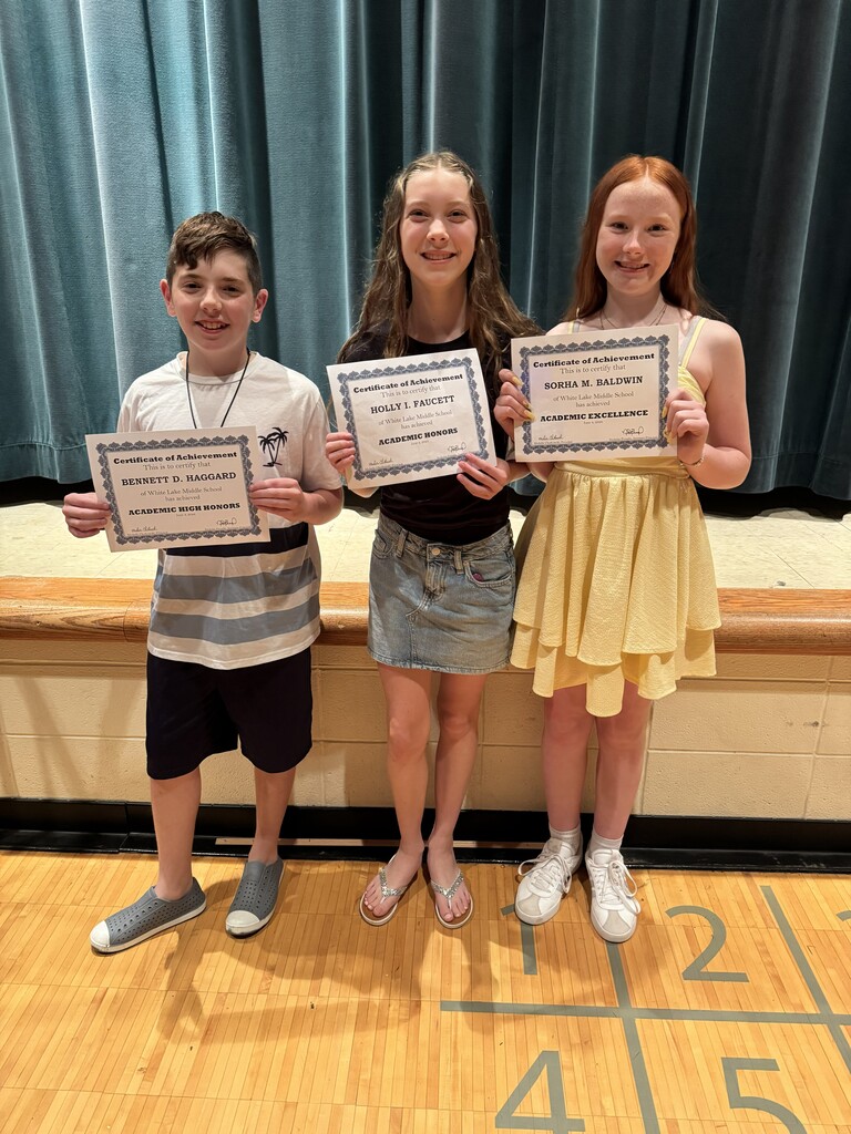 Three students posing for a photo holding up certificates