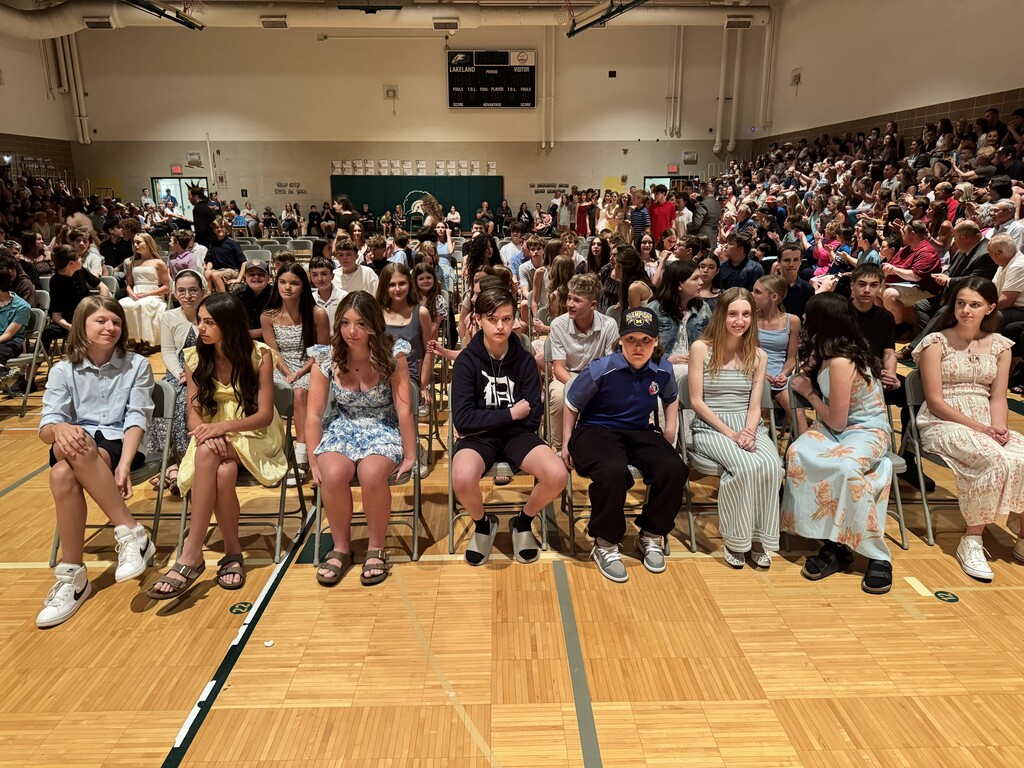 dozens students sitting on chairs in the gym during awards ceremony
