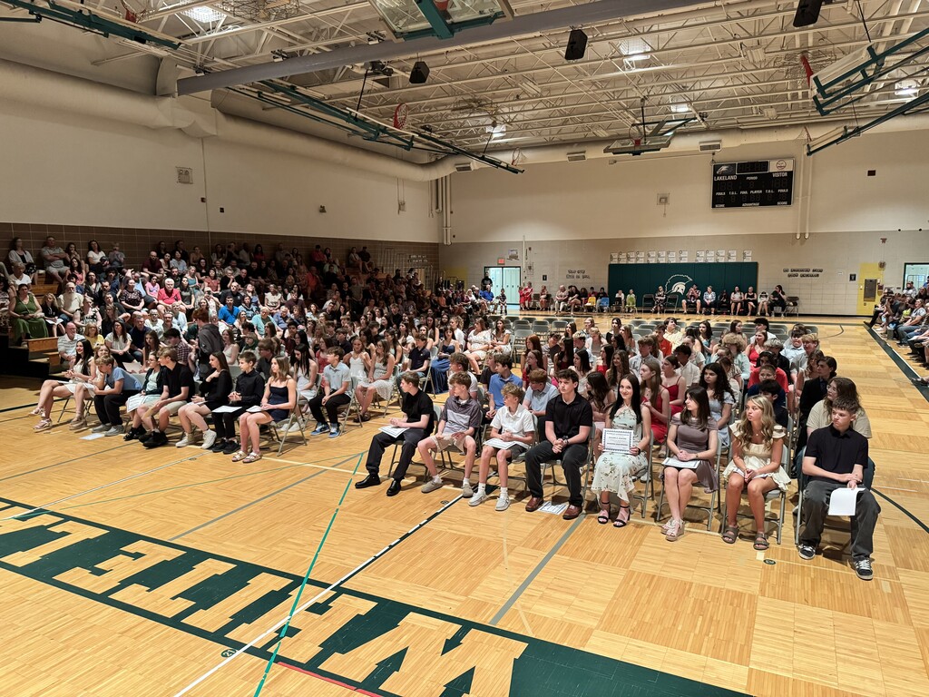 dozens students sitting on chairs in the gym during awards ceremony
