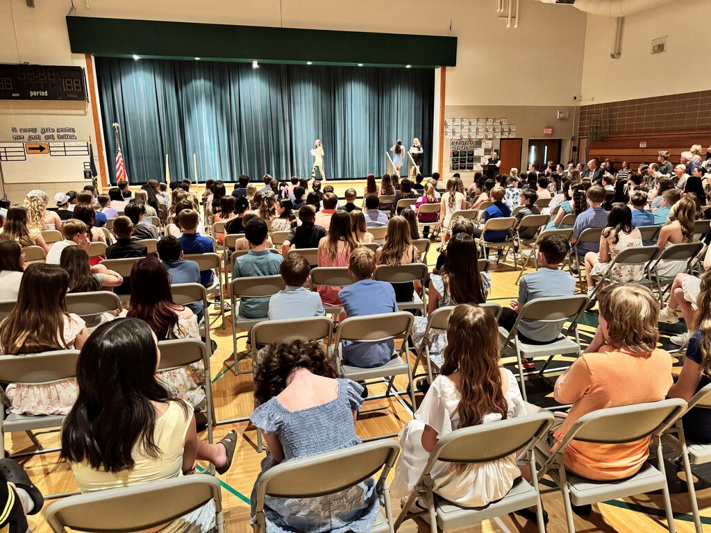 dozens students sitting on chairs in the gym during awards ceremony