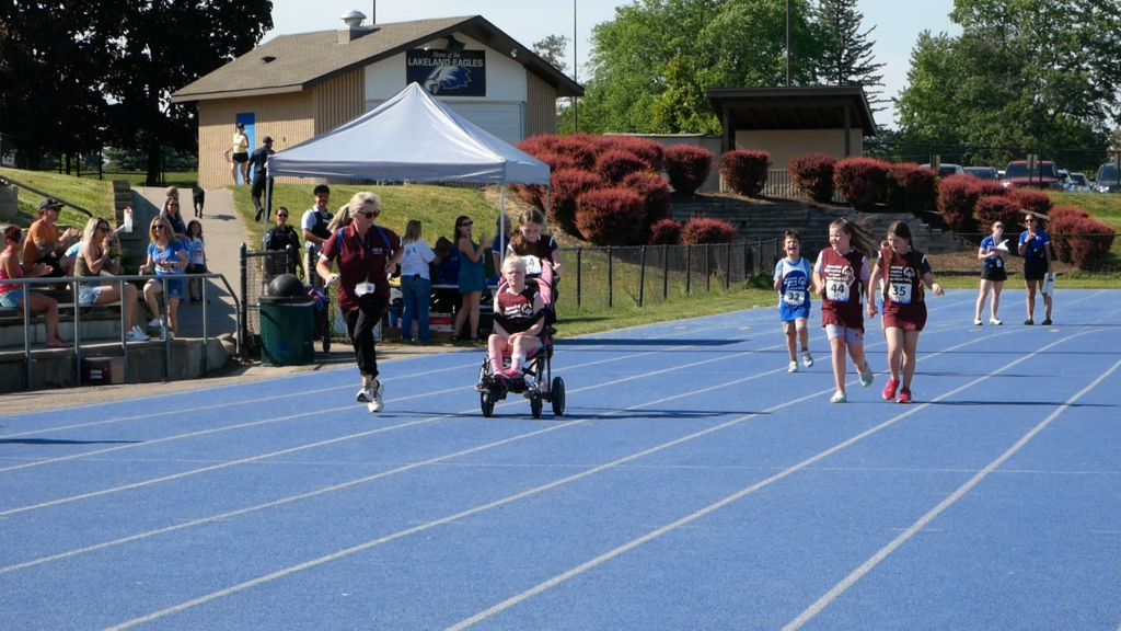 Athletes moving down the track during unified sports event