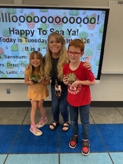 Woman with two students posing for a photo