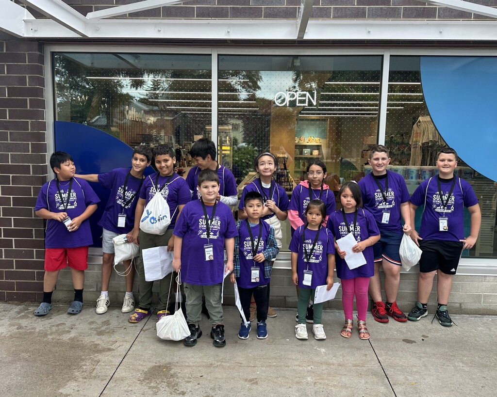 Several students in purple shirts posing for a photo 