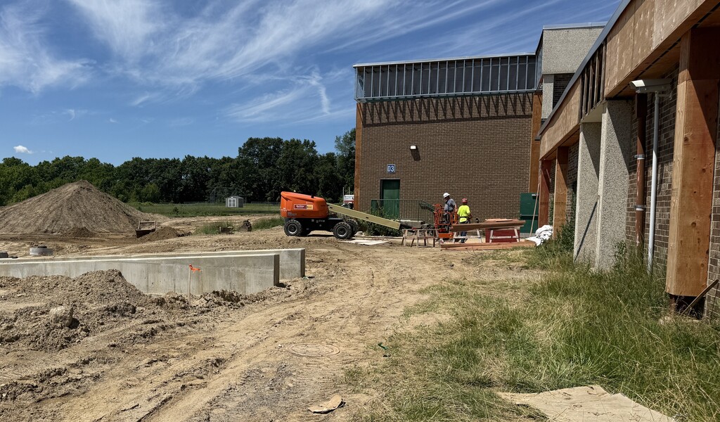 Photo of construction crews working on large site with brown dirt and heavy machinery