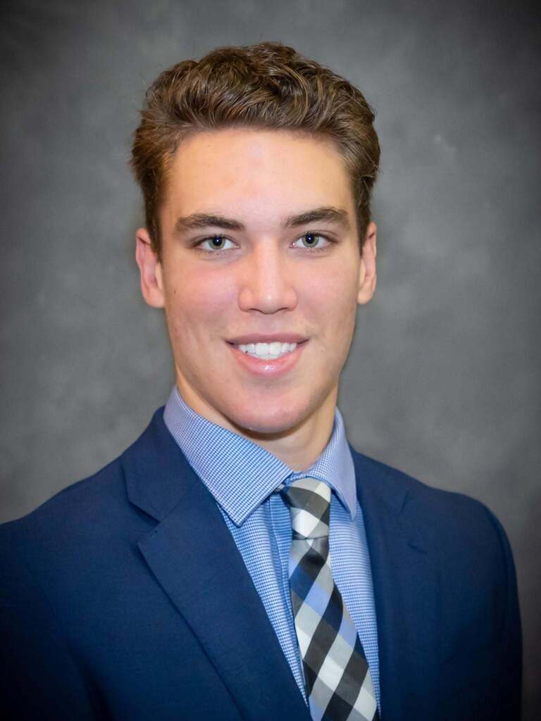 Photo of Jaden Grant, smiling in a suit