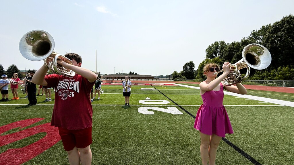 photo of marching band members marching on the football field