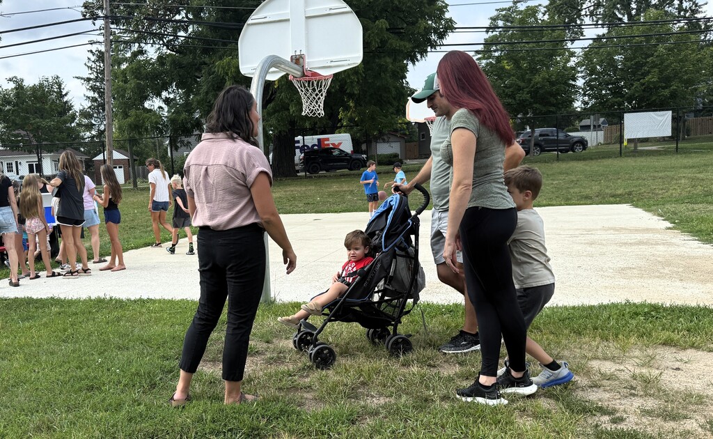 Woman talking to a family with a child in a stroller