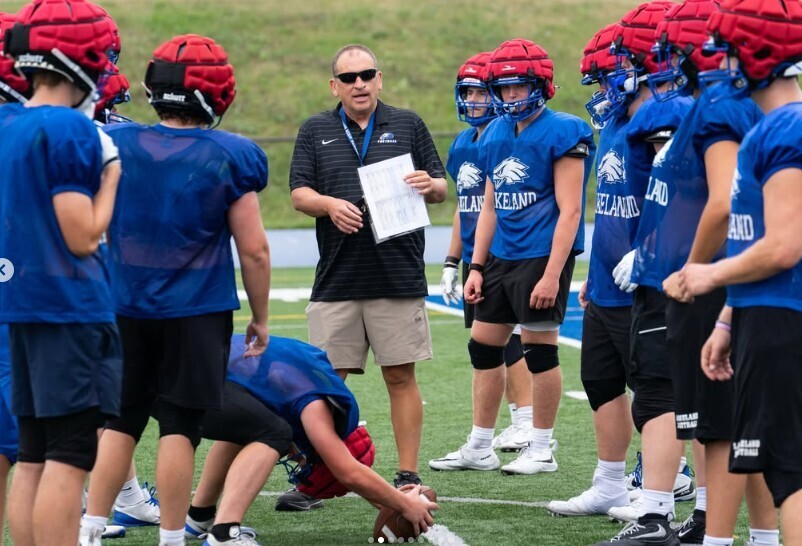 Photo of boys in football uniforms lining up and doing drills