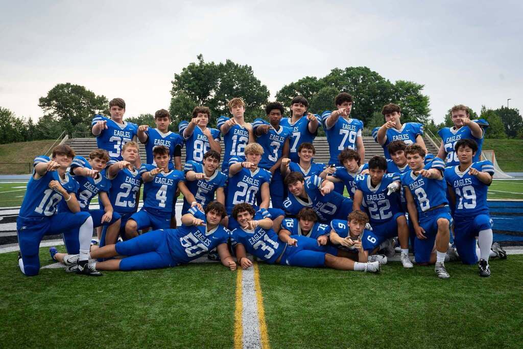 group Photo of boys in football uniforms posing on a football field