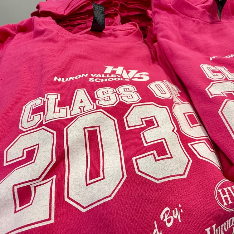 image of a close up photo of a stack of pink shirts on a table