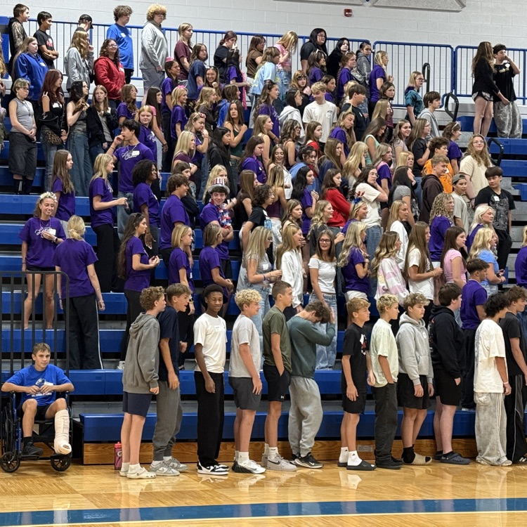 several high school students sitting on bleachers
