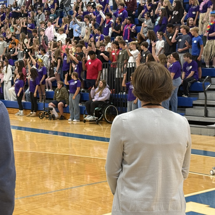 several high school students sitting on bleachers with people in the foreground