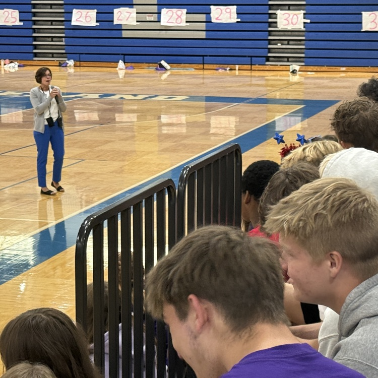 several high school students sitting on bleachers
