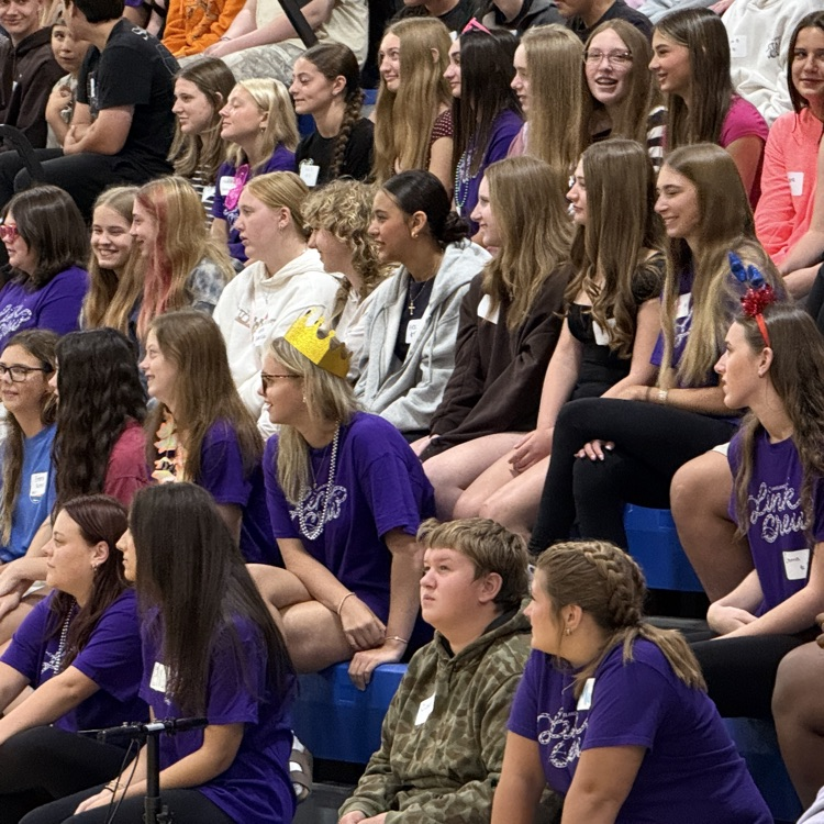 several high school students sitting on bleachers