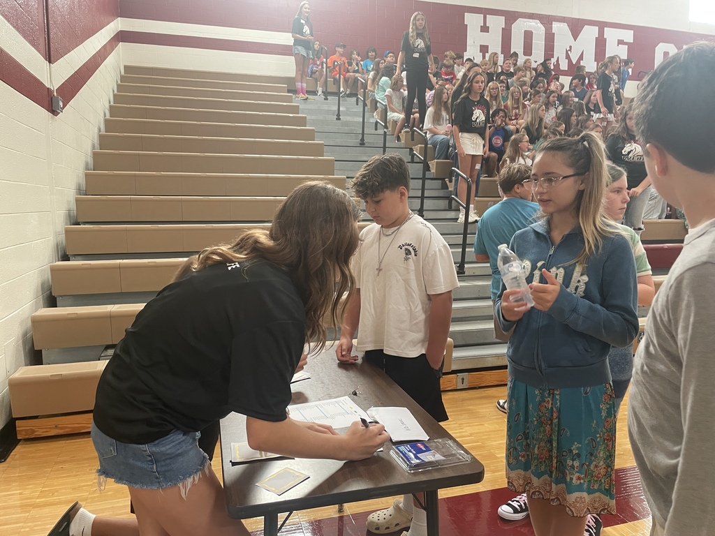 Person checking in kids/students at a table 