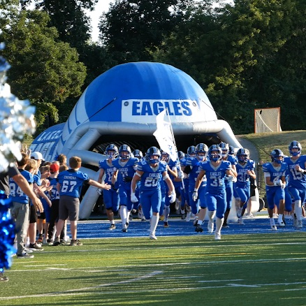 football players running onto a field
