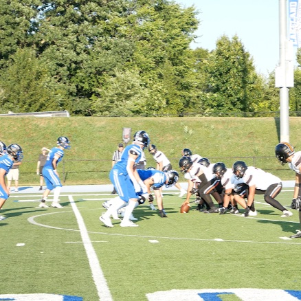 two teams lined up playing football on a field